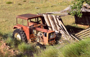 Yaşlı paslı traktör, ahşap bir baraka tutarak tarlaya terk edilmiş..  