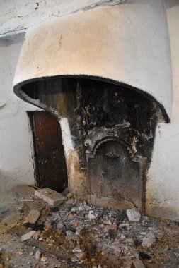 Tencereyi asmak için işlenmiş demir levhası ve zinciri olan eski odun yakan şömine..