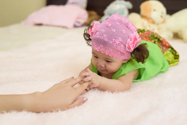 Asiatiska unga baby spela med mor hand. — Stockfoto