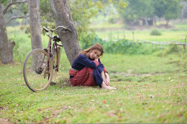 Jóvenes mujeres asiáticas sentadas junto al árbol con bicicleta en el campo de arroz a —  Fotos de Stock