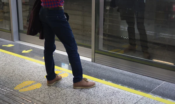Вид сзади человека носить джинсы и кожаные туфли в ожидании метро — стоковое фото