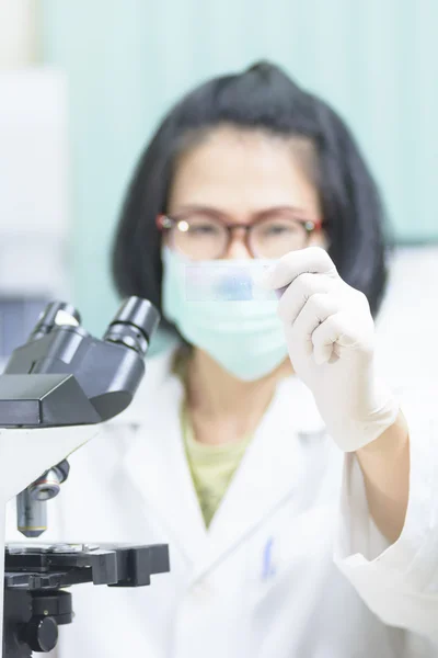 Cabelo curto jovem cientista analisando e mostrar microscópio — Fotografia de Stock