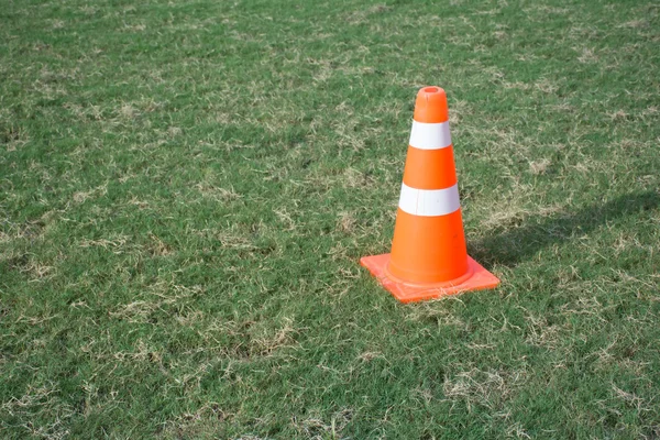 Оранжевый конус на зеленом футбольном поле — стоковое фото