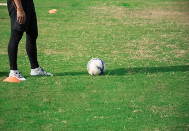 Futbol alanında duran futbolcu hazırlamak için tekme