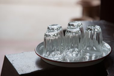 beş boş bardak beyaz tepsi ahşap masa üzerinde baş aşağı koymak