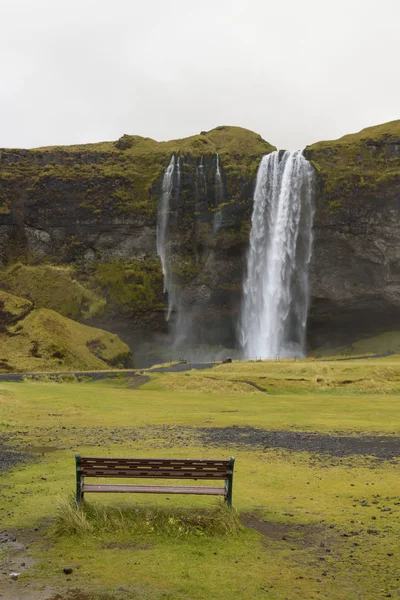 在下雨天的长凳上，斯科加瀑布，冰岛 — 图库照片