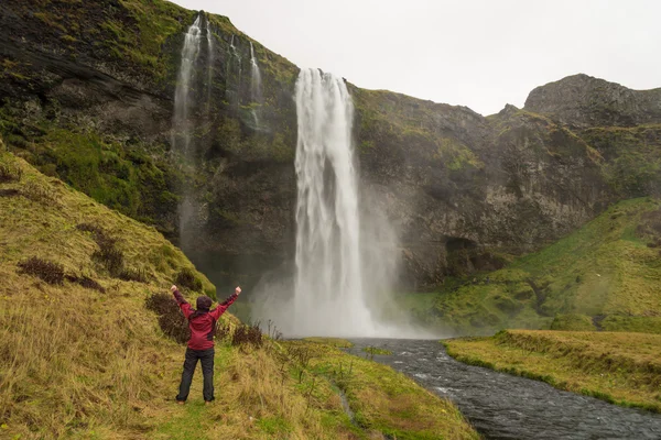 Glückliche Frau am Wasserfall skogafoss auf Island posiert gelassen — Stockfoto