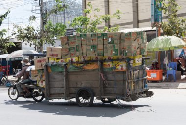 İşçiler motosiklet ve Tayland-Kamboçya sınır kasabası sepeti malın taşıma
