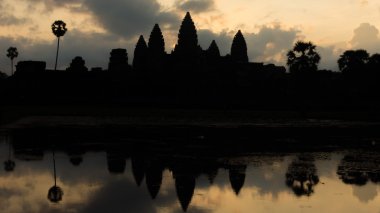 Güneş doğarken Angkor Wat kalıntıları. Tarihi antik tapınak ve su birikintisi Siem Reap Kamboçya yakın üzerinde yükselen güneşin yansıması.