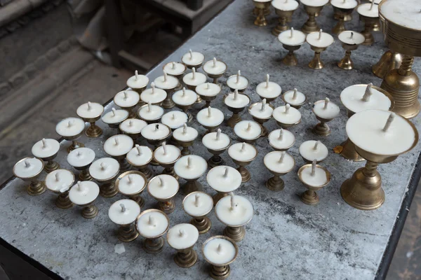 Kerzen reihten sich in einer Reihe im Kloster in Nepal. tibet, der himalaya. — Stockfoto