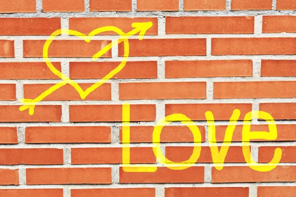Een hart en het woord love"" geschilderde ona bakstenen muur — Stockfoto