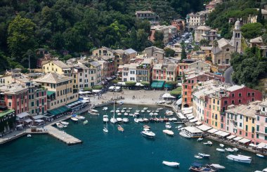 Liguria 'daki Portofino, İtalyan balıkçı köyü ve tatil beldesi, ünlü ve sanatsal ziyaretçilerle birlikte ünlü limanı ve tarihi birliği ile ünlüdür..