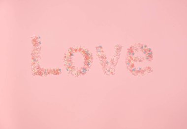 Pembe arka planda tatlı ile aşk kelimesi. Sevgililer Günün kutlu olsun, Anneler Günü, 8 Mart. Düz yatıyordu.