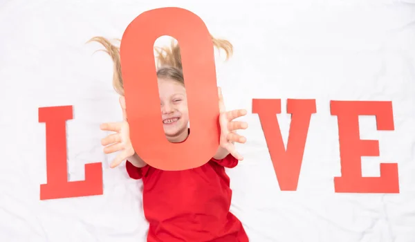 Een Klein Meisje Een Rood Shirt Ligt Een Bed Met — Stockfoto