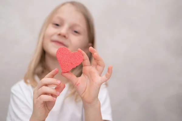 Una Chica Con Una Camiseta Blanca Esculpe Corazón Rosa Plastilina — Foto de Stock