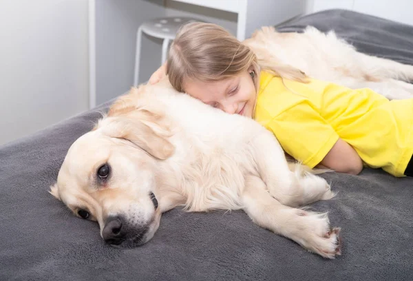 Little Girl Yellow Shirt Hugs Dog Bed Golden Retriever Playing — Stock Photo, Image