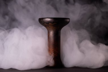 Duman arkaplanındaki toprak kaplama nargile kasesi. Nargile tütünü.