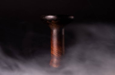 Duman arkaplanındaki toprak kaplama nargile kasesi. Nargile tütünü.