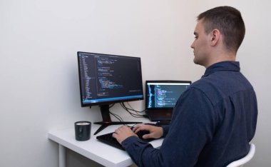 Evden çalışan bir erkek programcı. Erkek eller kodu yazıyorlar. Teknoloji ve ödev kavramı.
