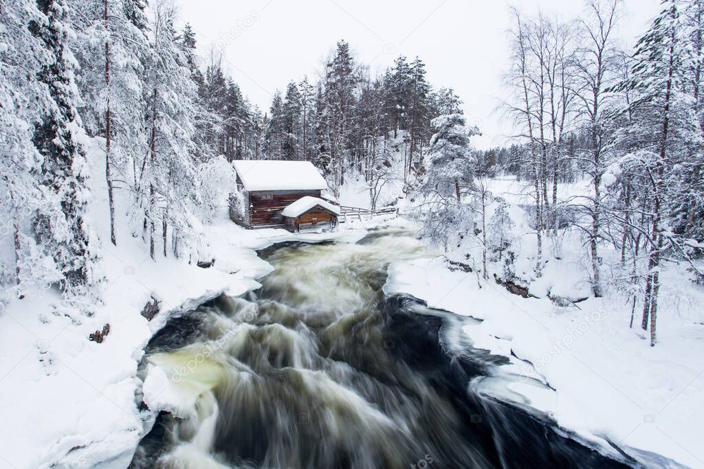 Oulanka National Park. Myllykoski watermill at Pieni Karhunkierros hiking trail during cold and wintery day with rapids flowing in Finnish nature, Northern Europe.