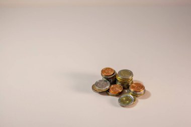 Işık arka planında bir yığın bozuk para. Boşluk alanı