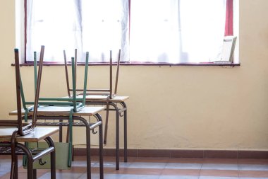 Masaların üstünde bebek okul sandalyeleri var. Fotoğraf yatay olarak çekiliyor..