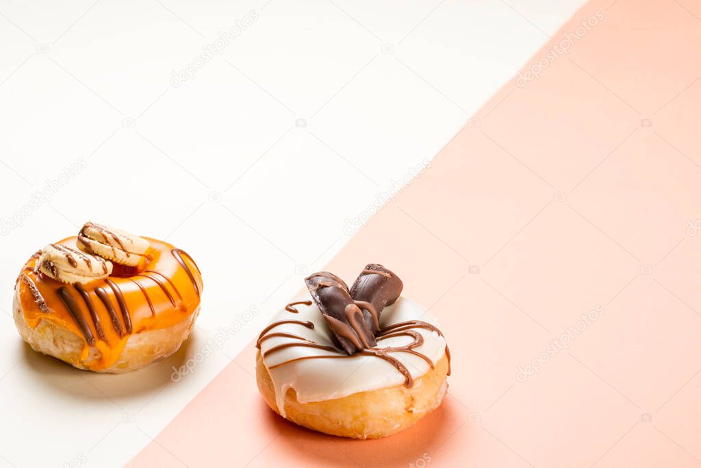 Photograph of two donuts decorated with cookies and drawn with chocolate.The photo is taken in horizontal format and it has copy space.