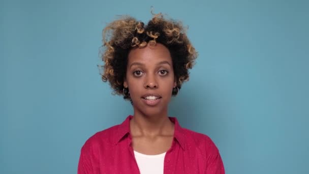 Mulher afro-americana muito jovem faz gesto de silêncio, pressiona dedo indicador para os lábios. — Vídeo de Stock