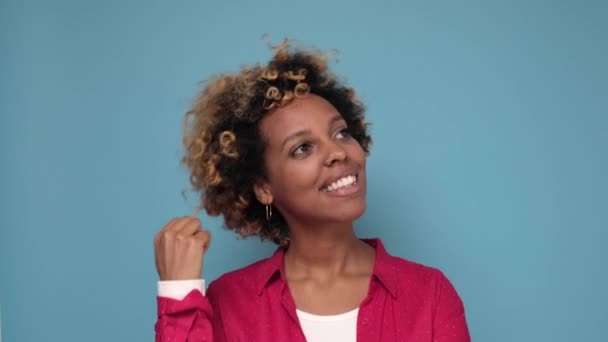 Vacker afroamerikansk kvinna med en lockig afro frisyr stående dagdrömmande. — Stockvideo