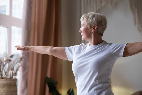 Mujer mayor realizando yoga en casa. Retrato de media longitud — Foto de Stock