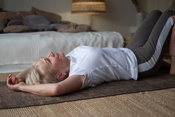 Senior Sporty Woman Practicing Yoga Lying Floor Resting Yoga Home — Stock Photo, Image