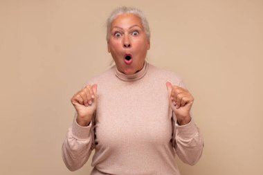 Şaşırmış ve şok olmuş yaşlı bir kadın. Vay canına, satın almak istiyorum. Stüdyo çekimi