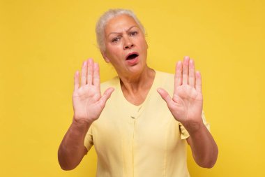 Yaşlı kadın avucunun içi gibi şarkı söylemeyi kesiyor. Olumsuz ve ciddi jest içeren uyarı ifadesi. - Benden uzak dur! Sosyal uzaklık kavramı.