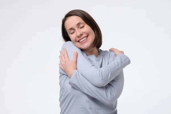 Middelbare leeftijd vrouw dragen knuffelen zichzelf gelukkig en positief, glimlachen zelfverzekerd — Stockfoto