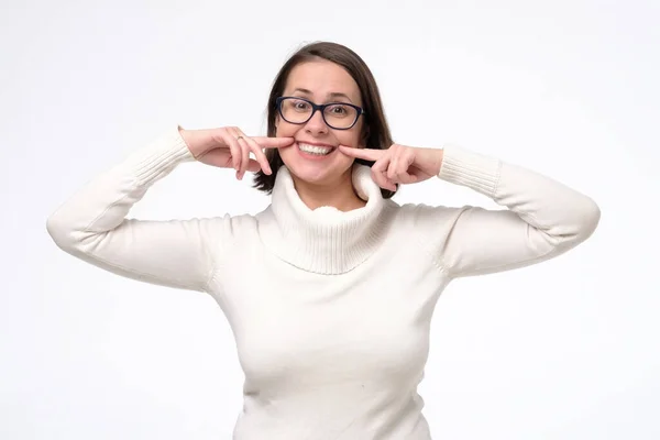 Mulher gesticulando seus dentes brancos e saudáveis com dois dedos indicador — Fotografia de Stock