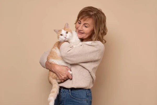 Mulher branca madura com óculos segurando um gato — Fotografia de Stock