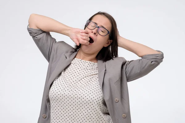 Mujer madura bostezando y estirándose después de un duro día de trabajo. —  Fotos de Stock