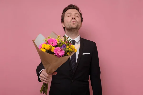 Sonriente hombre sosteniendo un ramo de flores haciendo una propuesta. — Foto de Stock