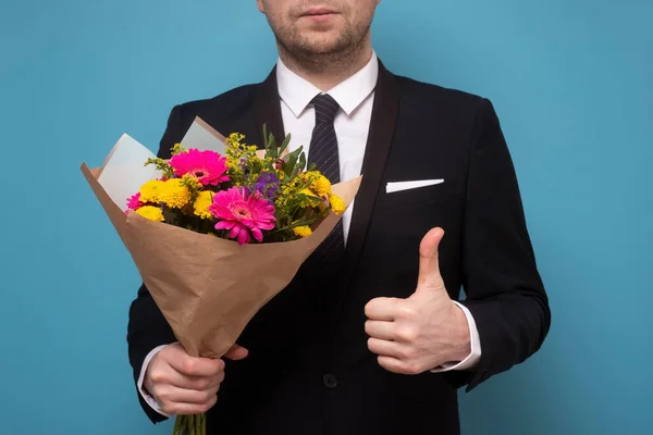 Mann mit schönem Blumenstrauß zeigt Daumen hoch. — Stockfoto