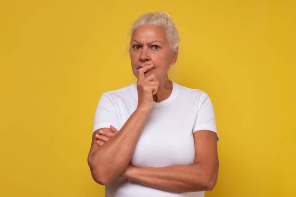 Расстроенная пожилая женщина, потерявшаяся в мыслях, скучающая по старым временам, думающая или размышляющая.