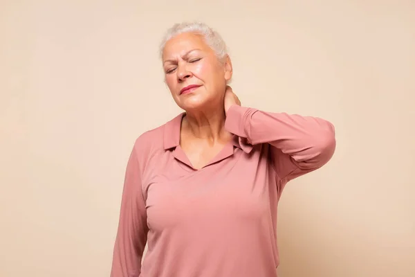 Mulher hispânica sênior segurando o pescoço com dor e desconforto — Fotografia de Stock