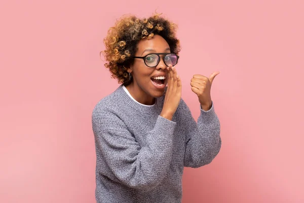口から秘密や噂を口にしながらささやく若いアフリカ系アメリカ人女性 ピンクの壁にスタジオショット — ストック写真