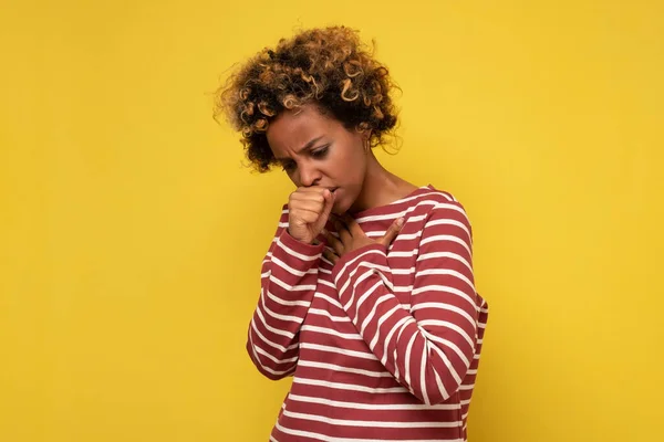 African american woman feeling unwell and coughing as symptom for cold or bronchitis. Healthcare concept.