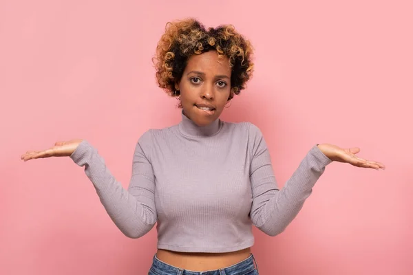 躊躇するアフリカ系アメリカ人女性は言葉を困惑させ、肩を不確実性ですくめ、顔をしかめ — ストック写真