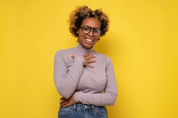 アフリカ系アメリカ人の女性は、巻き毛を持つ、肯定的な話や褒め言葉を聞いて喜んでいる、心に手を保つ — ストック写真