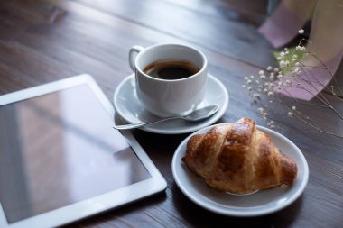Cappuchino ile ay çöreği tablet ile yakın çekim.