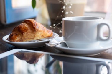 Cappuchino ile ay çöreği tablet ile yakın çekim.