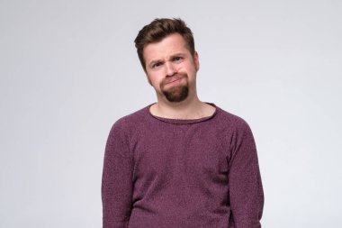 Yanaklarını şişiren sakallı, yorgun beyaz bir adam..