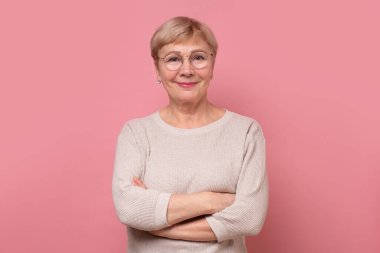 Mutlu yaşlı bayan kameraya bakıyor ve gülümsüyor.