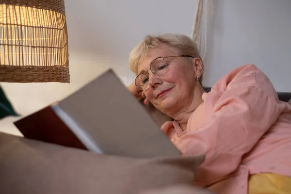 Senior kaukasiska kvinna hemma läsa bok — Stockfoto